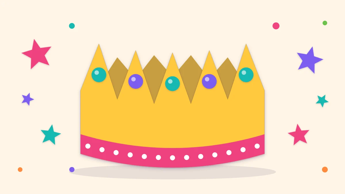 A yellow paper birthday crown with five points, a pink band and round paper gems, standing on a table